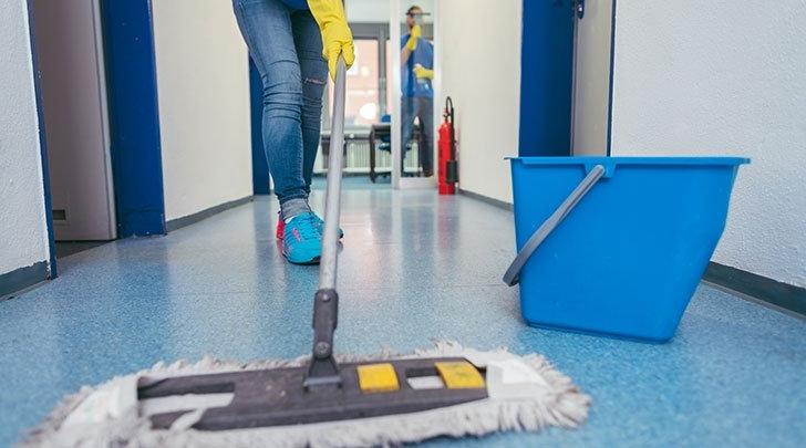 a worker mops a blue tile floor